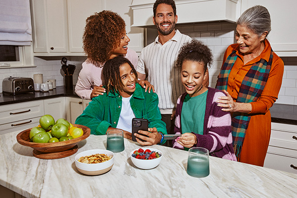 Picture of family in kitchen looking at Greenlight app