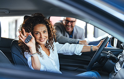 Woman with keys to new car in her hand