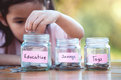 Image of child putting coins in a jar